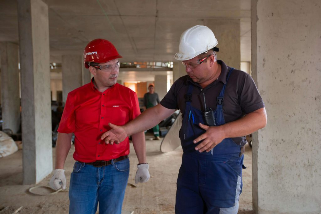 figure responsabili della sicurezza in cantiere edile che discutono del progetto in fase di esecuzione